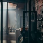 A dark and atmospheric gym interior showcasing weights and fitness equipment with dramatic lighting.