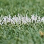 Detailed close-up of a white line on artificial green turf, perfect for sports backgrounds.